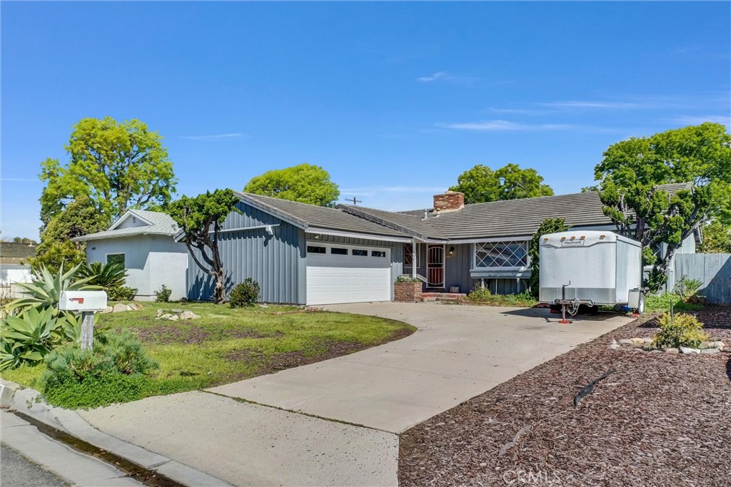a front view of a house with a yard and potted plants