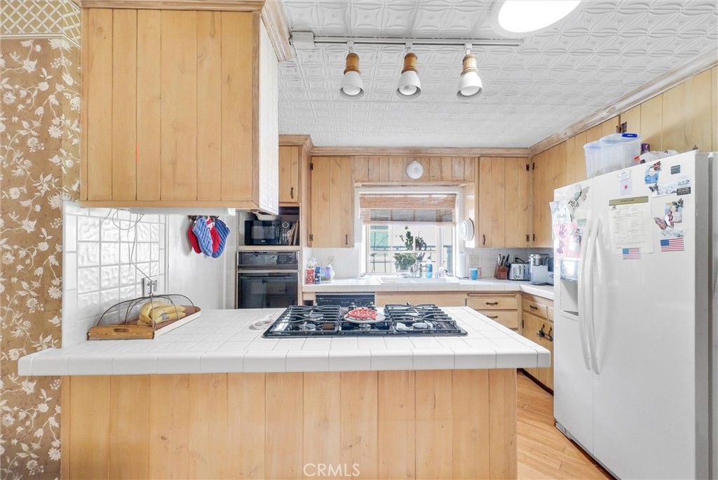 440 Cabrillo Street Costa Mesa, CA 92627 - Photo 15 of 36 a kitchen with a refrigerator a stove and a window