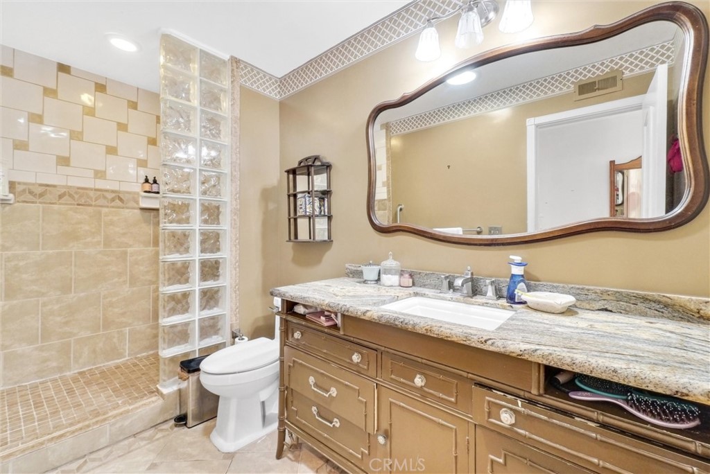 440 Cabrillo Street Costa Mesa, CA 92627 - Photo 23 of 36 a bathroom with a granite countertop toilet sink and mirror