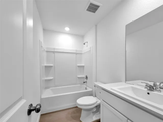 a bathroom with a sink a toilet a mirror and bathtub