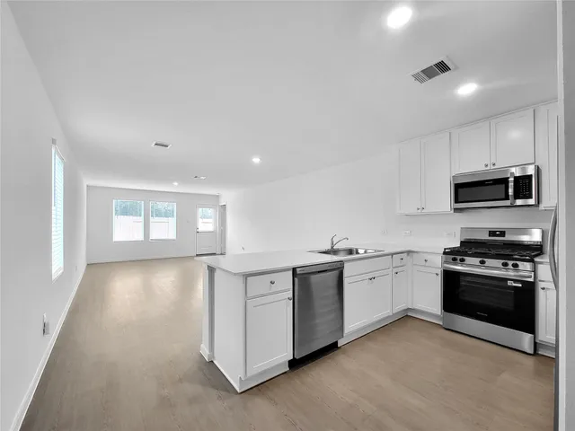 a kitchen with stainless steel appliances granite countertop a stove and a sink