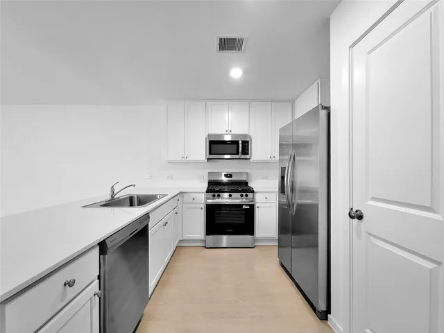 a kitchen with a sink and stainless steel appliances
