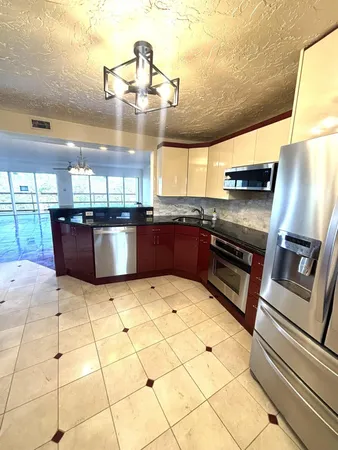 a kitchen with stainless steel appliances granite countertop a sink and a counter top space