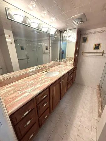 a bathroom with a granite countertop sink a large mirror and a shower