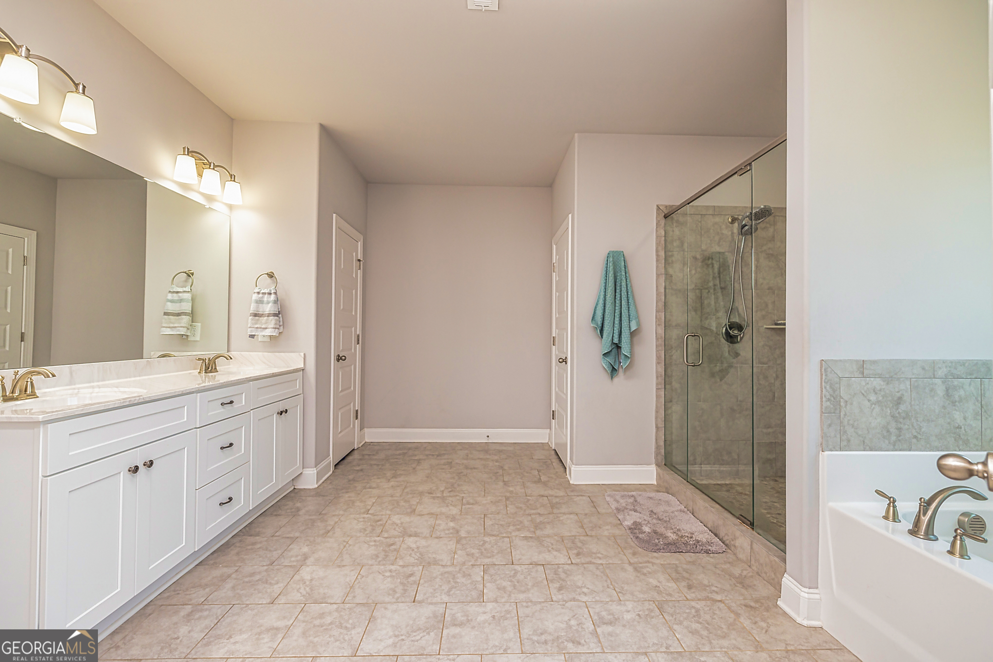 941 Highway 16 Newnan, GA 30263 - Photo 19 of 43 a spacious bathroom with a granite countertop sink a mirror a bathtub and shower