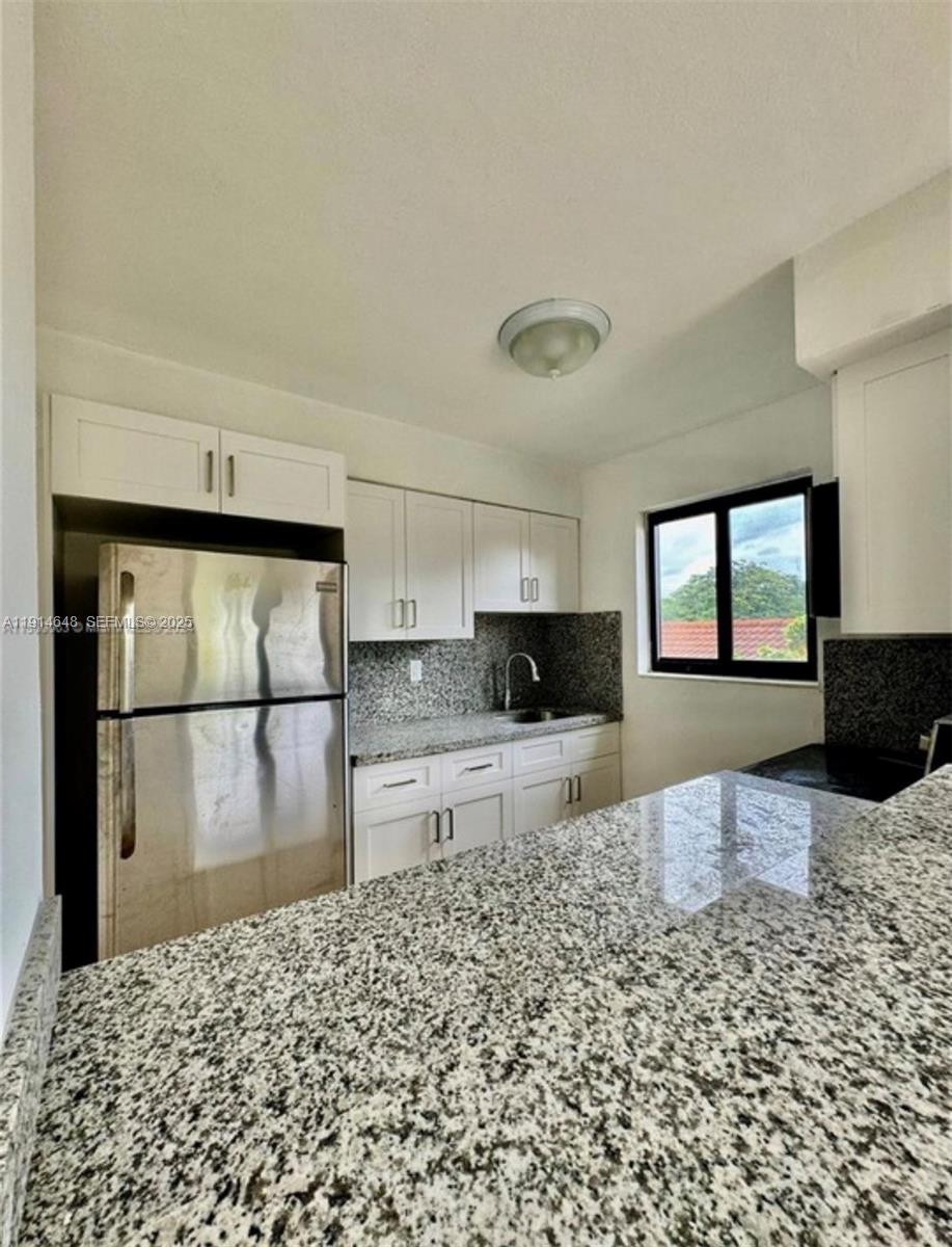 3520 Southwest 25th Street Miami, FL 33133 - Photo 7 of 43 a kitchen with a refrigerator and a stove top oven