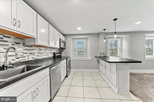 a kitchen with stainless steel appliances granite countertop a sink counter space cabinets and a a window