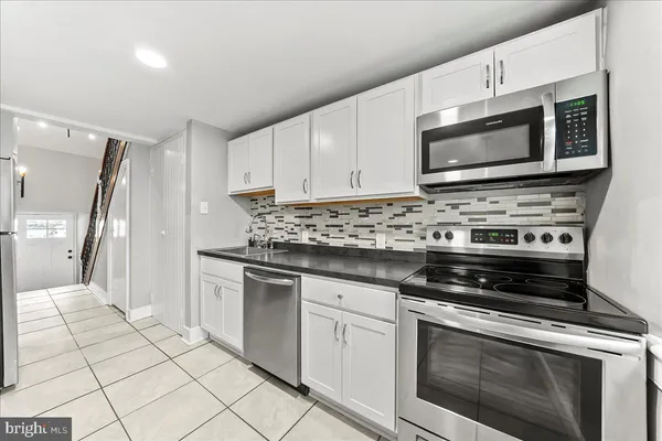 a kitchen with stainless steel appliances granite countertop a stove microwave and cabinets