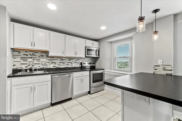 a kitchen with granite countertop a sink window and cabinets