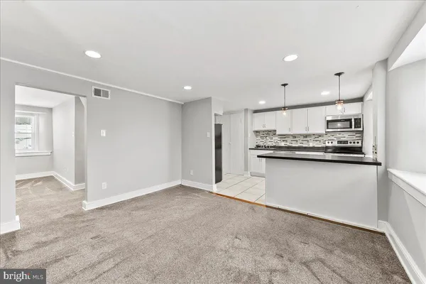 a view of kitchen with kitchen island a sink appliances and cabinets