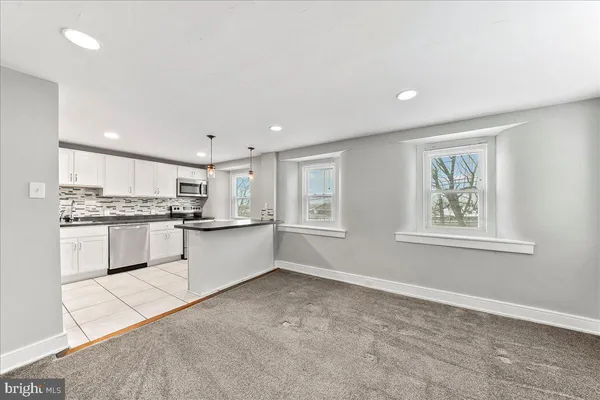 a large kitchen with kitchen island a sink stainless steel appliances and cabinets