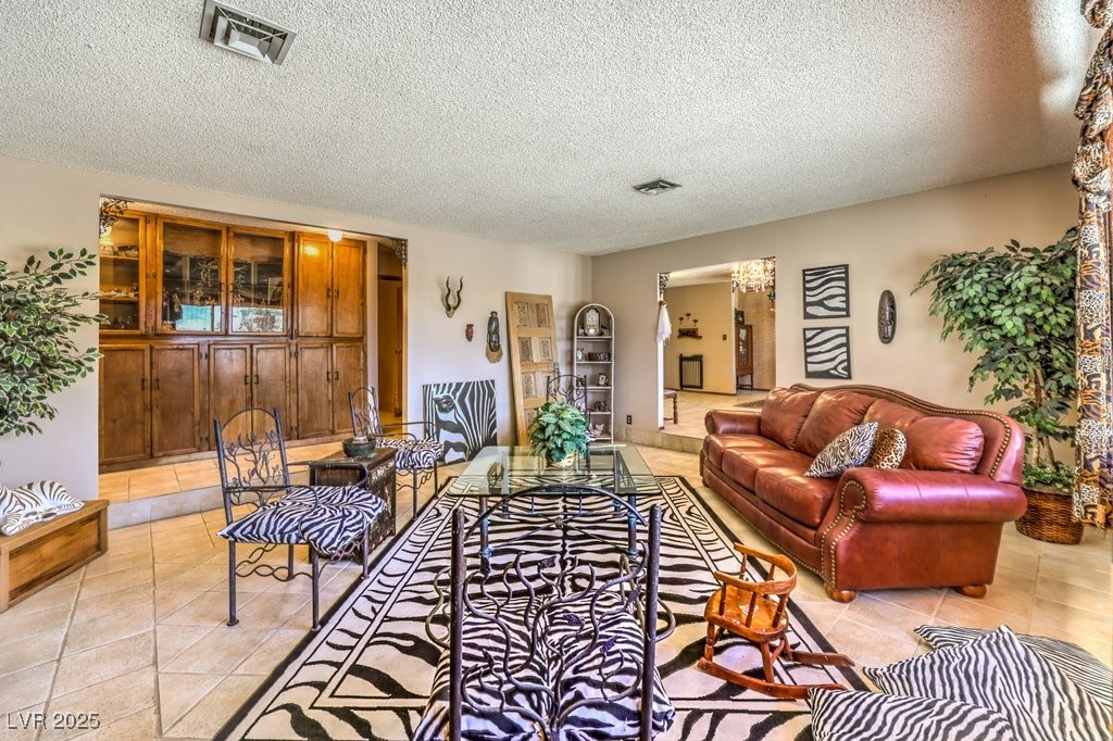 10615 Rancho Destino Road Las Vegas, NV 89183 - Photo 12 of 53 Living area with light tile patterned floors, visible vents, and a textured ceiling