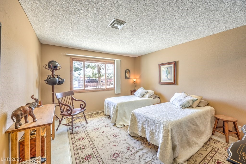 10615 Rancho Destino Road Las Vegas, NV 89183 - Photo 31 of 53 Bedroom with visible vents, baseboards, and a textured ceiling