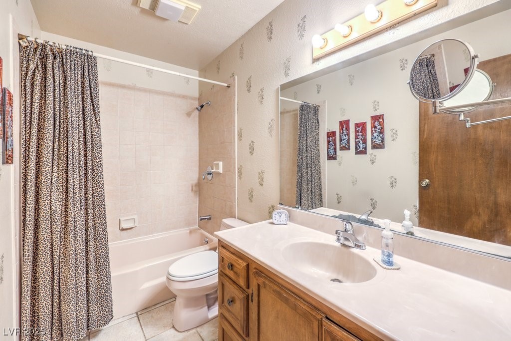 10615 Rancho Destino Road Las Vegas, NV 89183 - Photo 33 of 53 Full bathroom featuring tile patterned flooring, toilet, shower / bath combo with shower curtain, and wallpapered walls