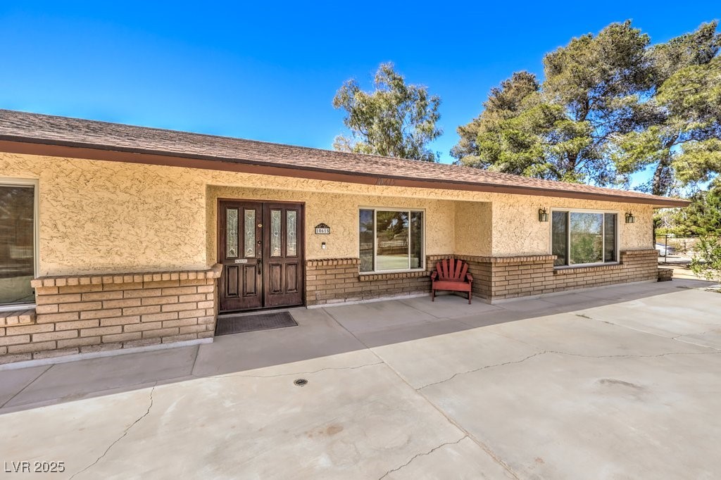 10615 Rancho Destino Road Las Vegas, NV 89183 - Photo 6 of 53 Doorway to property featuring stucco siding, brick siding, and french doors