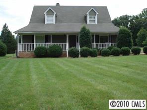 a front view of a house with yard and green space