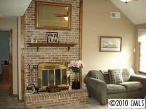 9800 Surrey Road Charlotte, NC 28227 - Photo 3 of 8 a living room with furniture a flat screen tv and a fireplace