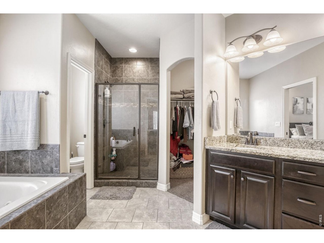7992 St Street Frederick, CO 80530 - Photo 18 of 28 a bathroom with a granite countertop sink shower and a mirror