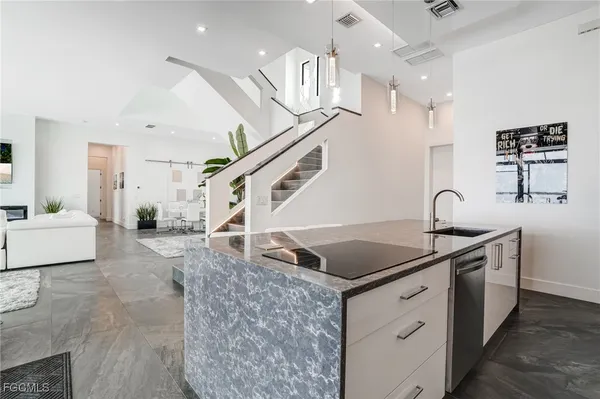 a kitchen with stainless steel appliances granite countertop a sink refrigerator and cabinets