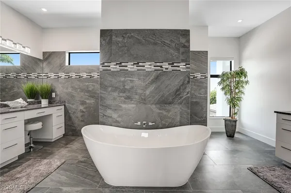 a bathroom with a granite countertop sink a mirror and shower