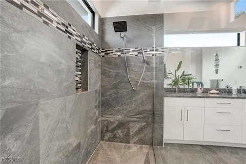 a bathroom with a double vanity sink mirror and shower