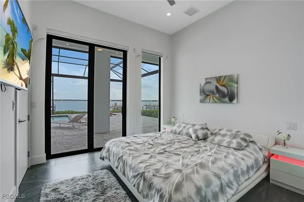 a bedroom with a large bed and a flat tv screen on dresser