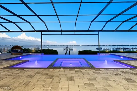 a view of swimming pool with red chairs