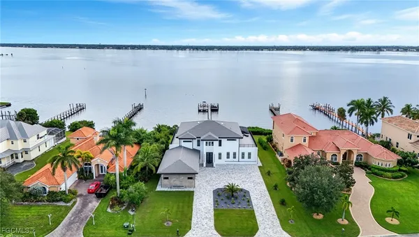 a aerial view of a house with a yard and a large tree