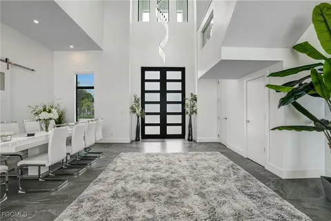 a living room with furniture large windows and a rug