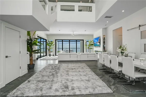 a living room with furniture large windows and a rug