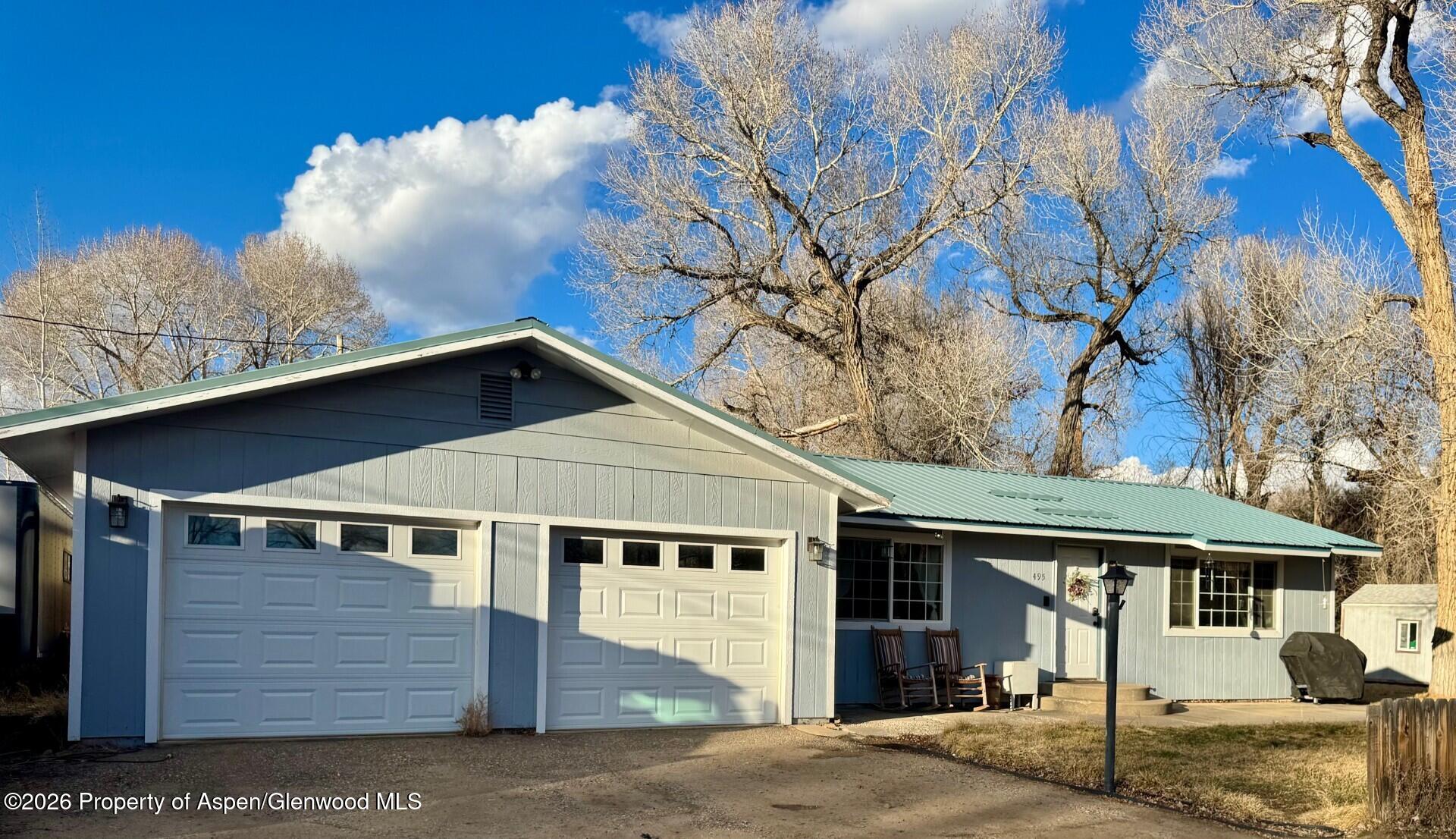 a front view of a house with a tree