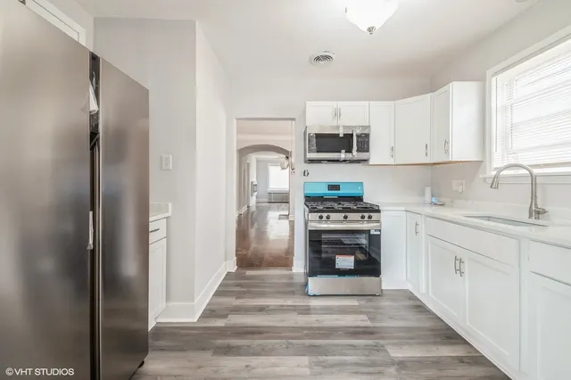 a kitchen with stainless steel appliances a stove sink and refrigerator
