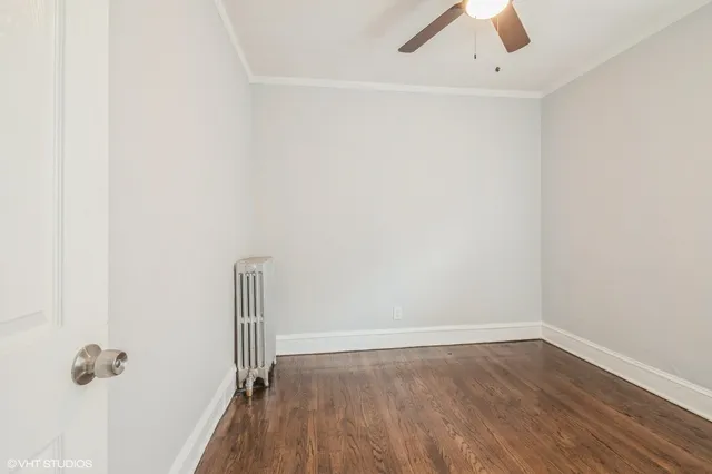 an empty room with a hardwood and ceiling fan