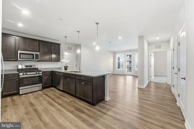 a large kitchen with granite countertop a large counter top stainless steel appliances and cabinets