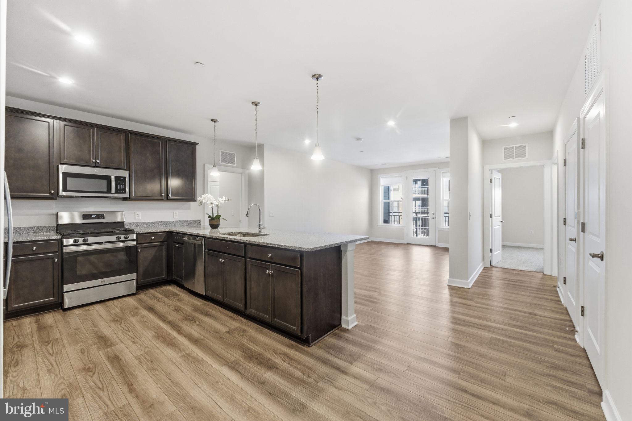 3925 Fair Ridge Drive, Unit 304 Fairfax, VA 22033 - Photo 12 of 44 a large kitchen with granite countertop a large counter top stainless steel appliances and cabinets