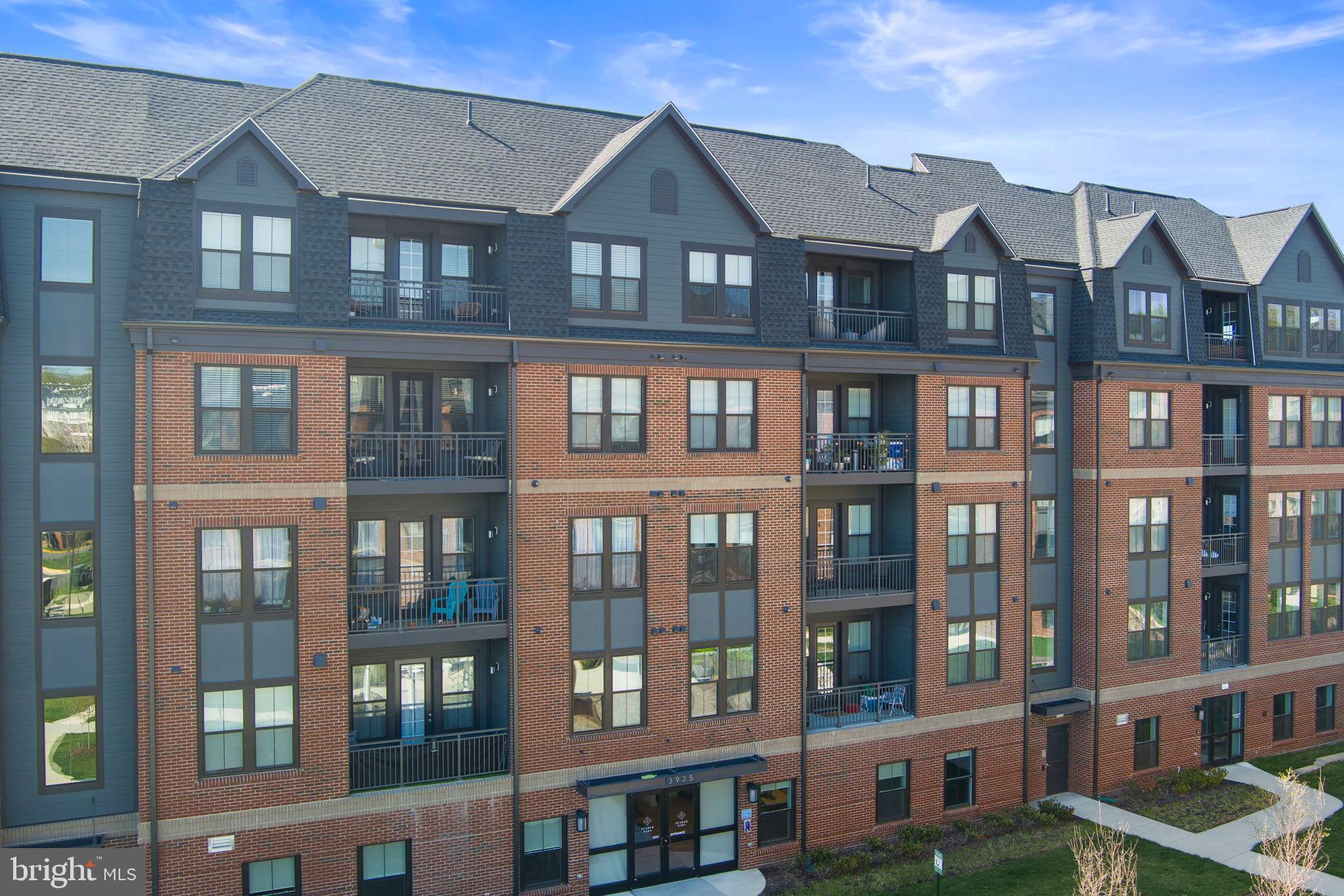 3925 Fair Ridge Drive, Unit 304 Fairfax, VA 22033 - Photo 2 of 44 a front view of a residential apartment building with a yard