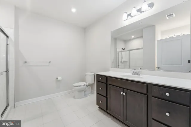 a spacious bathroom with a toilet sink and mirror