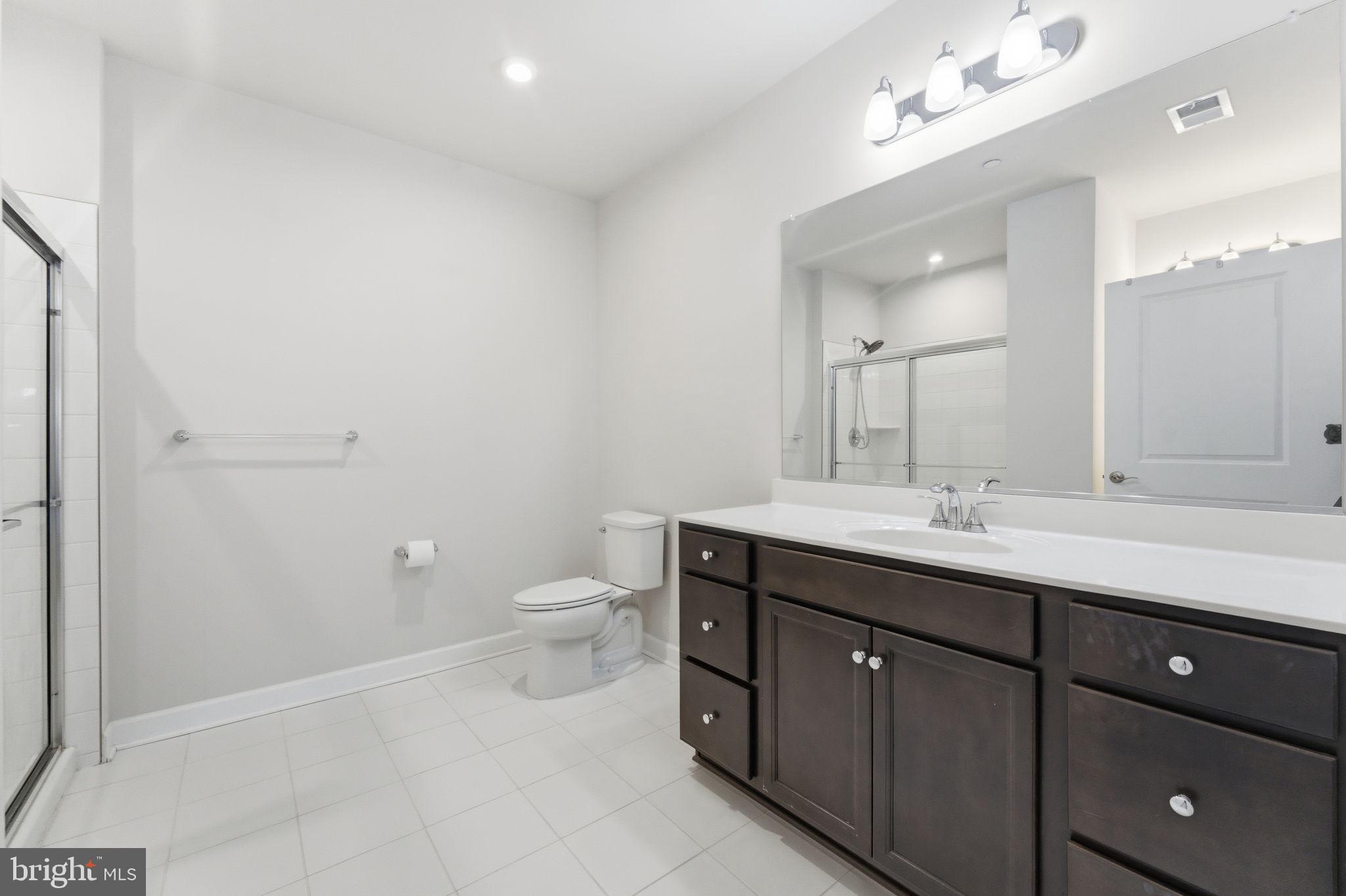 3925 Fair Ridge Drive, Unit 304 Fairfax, VA 22033 - Photo 31 of 44 a spacious bathroom with a toilet sink and mirror