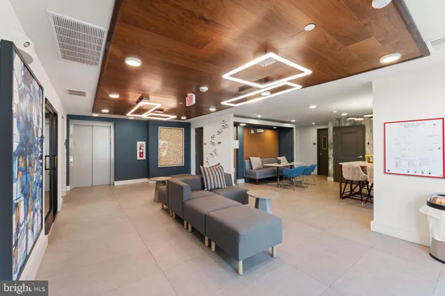 a living room with furniture kitchen view and a large window