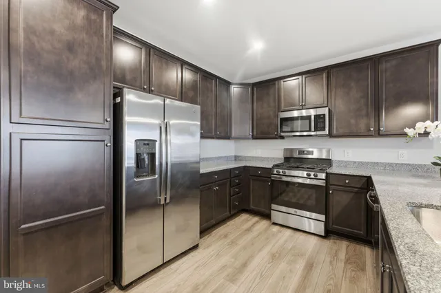 a kitchen with granite countertop stainless steel appliances and a refrigerator