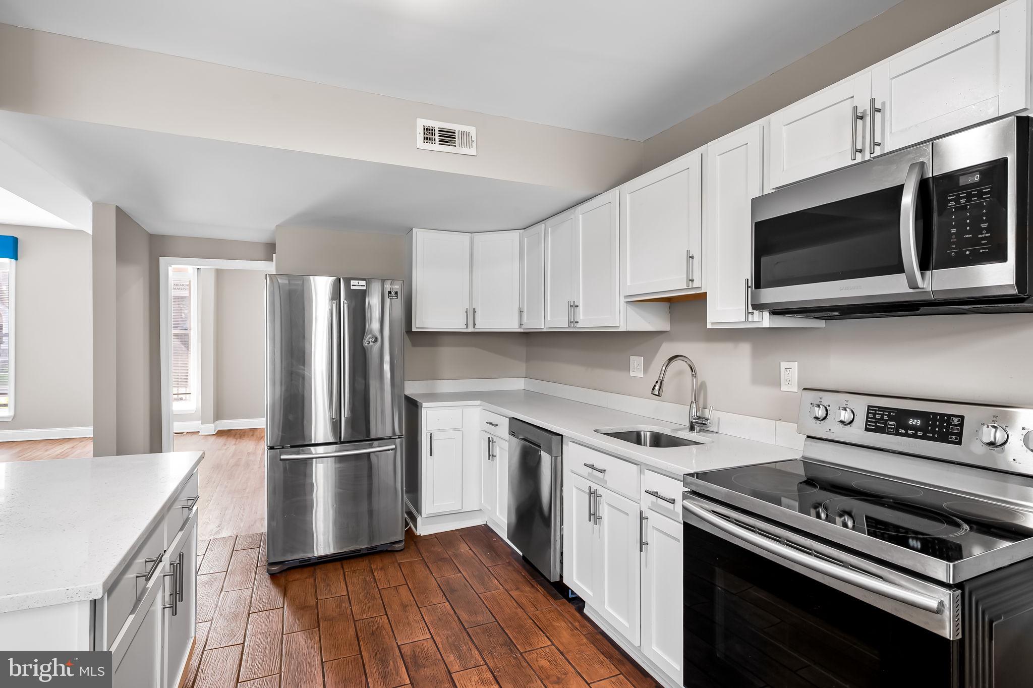 4021 Park Heights Avenue Baltimore, MD 21215 - Photo 13 of 32 a kitchen with a sink stove and microwave