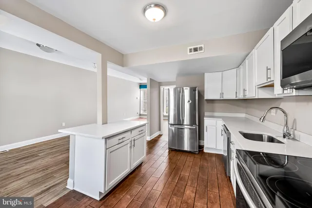a kitchen with stainless steel appliances a stove a sink and a refrigerator