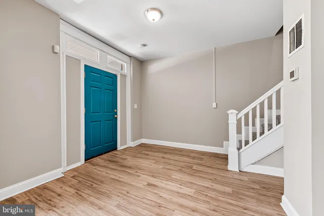 a view of a hallway with wooden floor and entryway