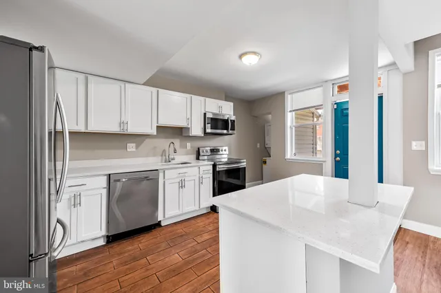 a kitchen with granite countertop white cabinets and white appliances