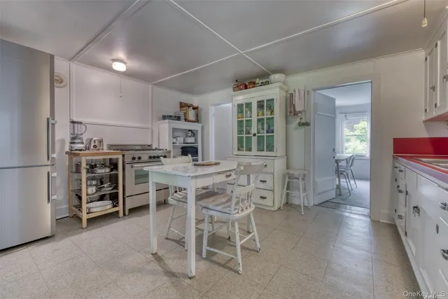 a dining hall with stainless steel appliances granite countertop a stove and a refrigerator