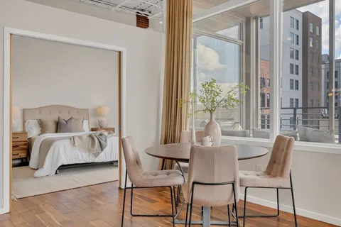 a dining room with furniture a large window and a chandelier