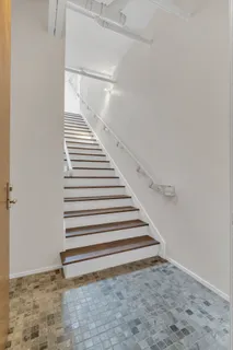 a view of a room with stairs and a ceiling fan