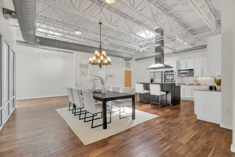 a view of a dining room with furniture a chandelier and wooden floor