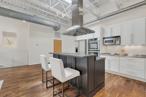 a kitchen with stainless steel appliances granite countertop a microwave a stove and white cabinets