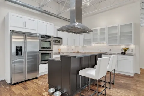 a kitchen with kitchen island white cabinets and stainless steel appliances